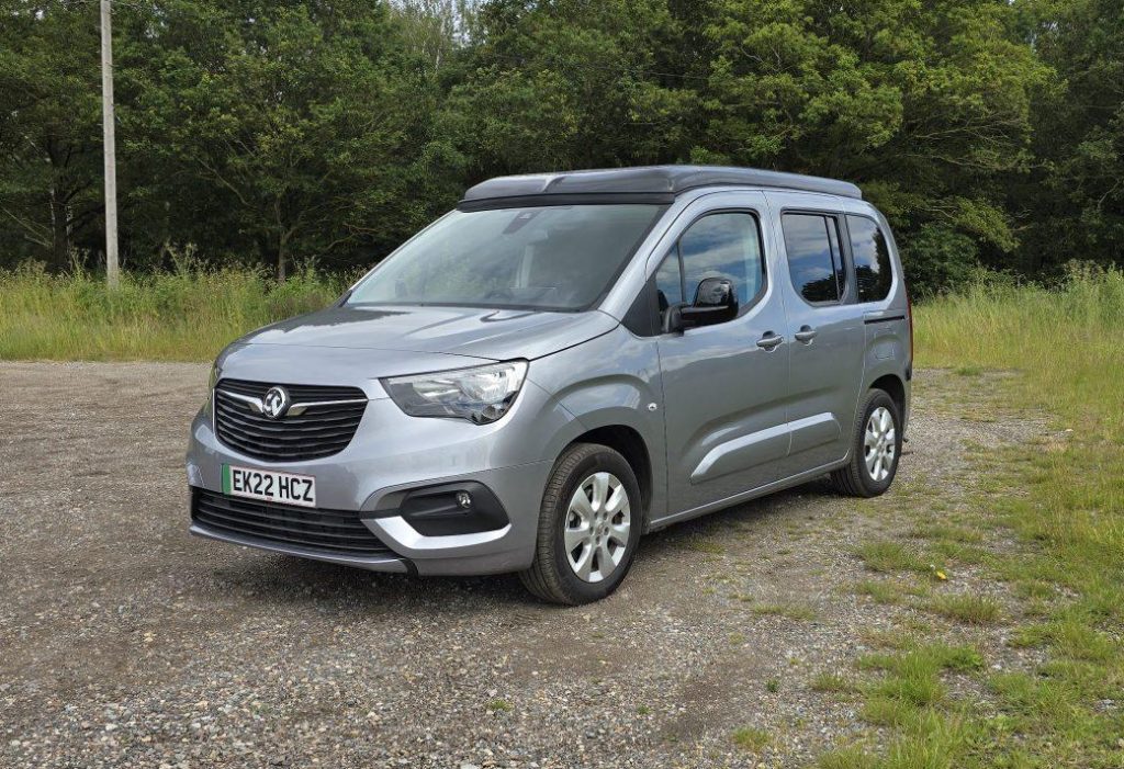Silver Vauxhall Combo Life-e Vikenze II camper car with roof closed parked on a gravel area