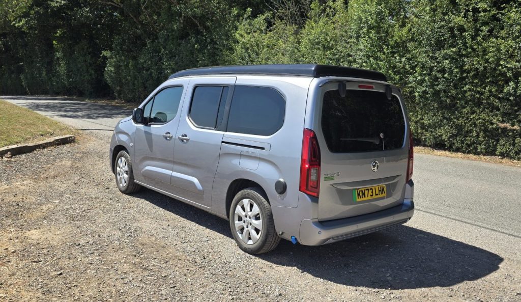 Silver Vikenze II camper car rear three-quarter view showing compact garageable design on country road