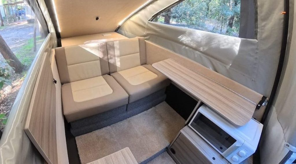 Dashaway eCT interior lounge with cream leather seating, fold-out table, microwave, and LED lighting