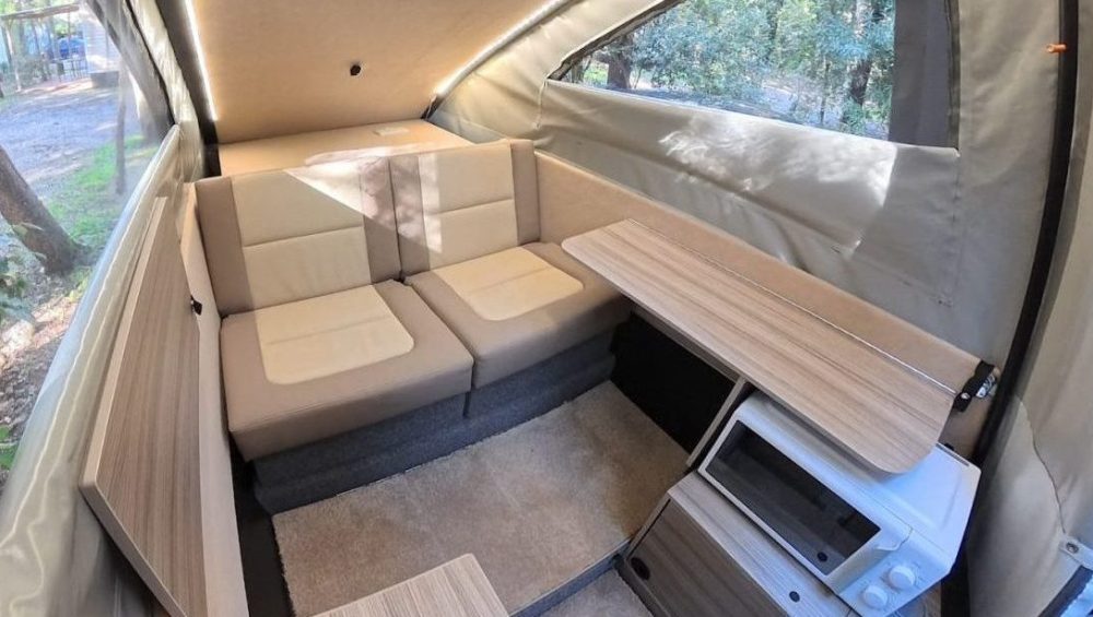 Dashaway eCT interior lounge with cream leather seating, fold-out table, microwave, and LED lighting